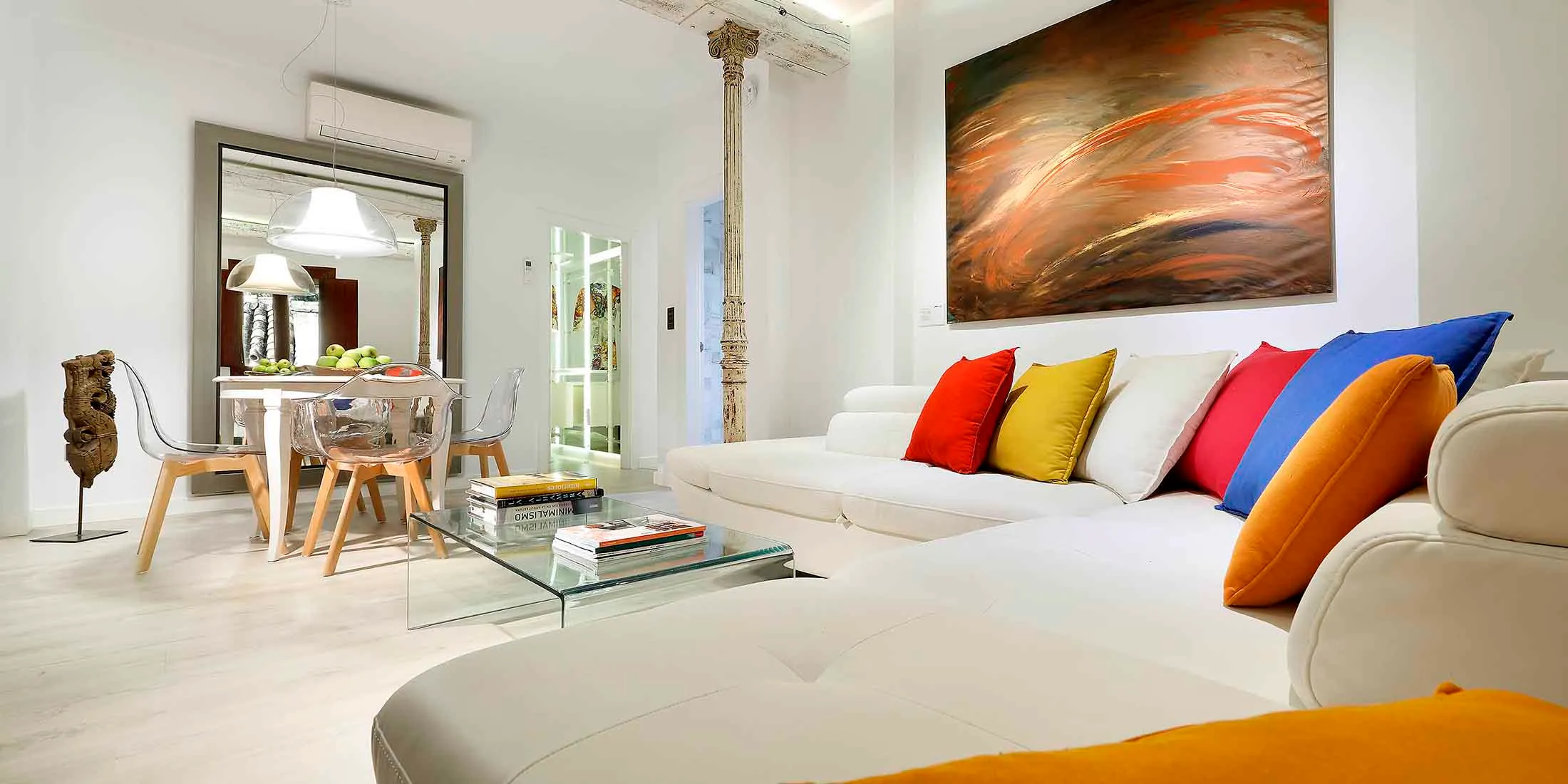 Salon d'un appartement en location avec canapé, table et cuisine ouverte