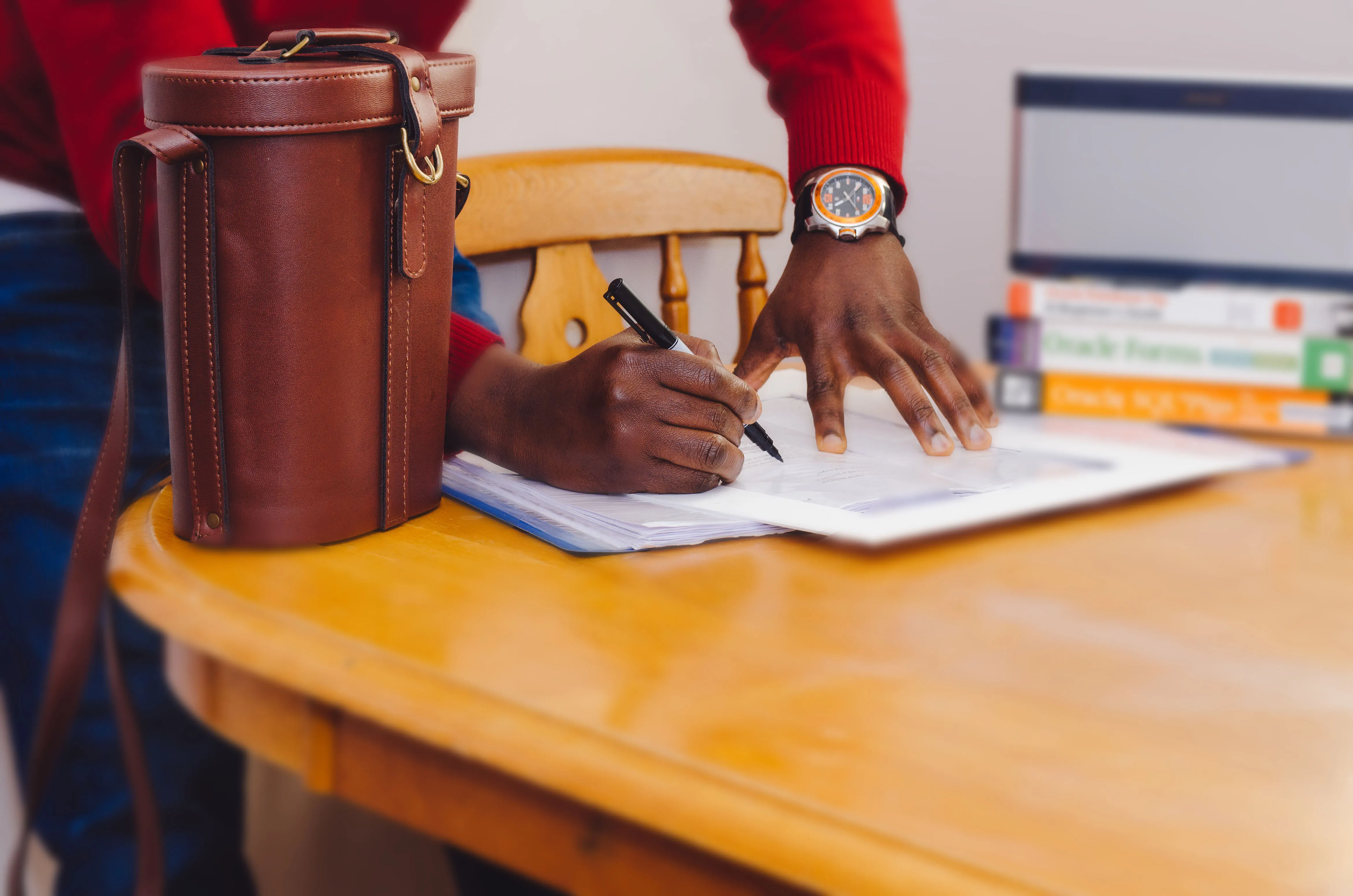 Main écrivant sur un document sur un bureau, pour illustrer la signature d'un bail